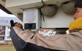Arbeiter montiert einen Lautsprecher einer Klangattrappe an ein Schwalbenhaus